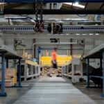 Leader walking through an industrial factory while assessing business performance