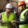 Two manufacturing colleagues in safety equipment discussing a workplace problem